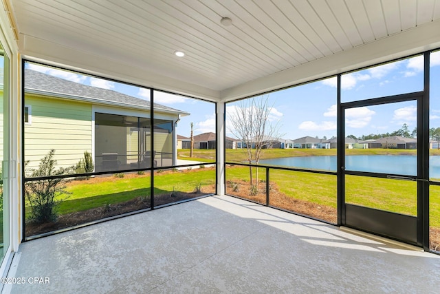 unfurnished sunroom with a residential view and a water view