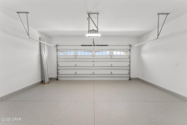 garage featuring a garage door opener and baseboards