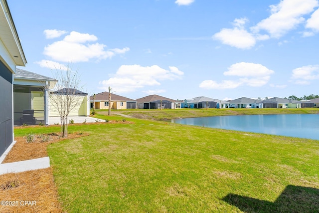 view of yard with a residential view and a water view