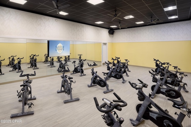 exercise room with a drop ceiling and ceiling fan