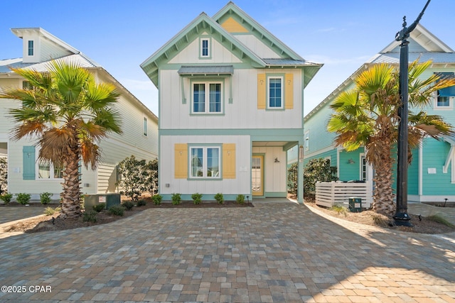 view of front of home with decorative driveway and board and batten siding