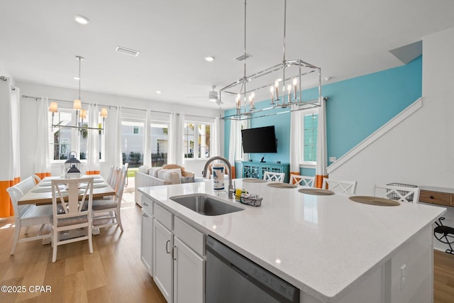 kitchen with visible vents, open floor plan, stainless steel dishwasher, a notable chandelier, and a sink