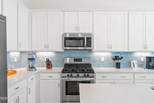 kitchen featuring backsplash, white cabinets, appliances with stainless steel finishes, and light stone counters