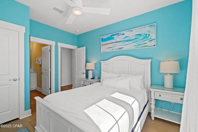 bedroom featuring a ceiling fan, wood finished floors, visible vents, and baseboards