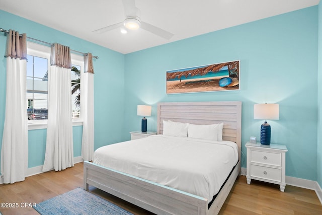 bedroom featuring a ceiling fan, baseboards, and wood finished floors