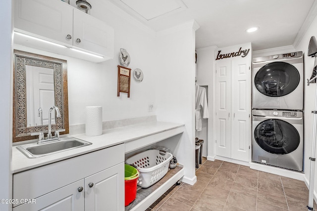 clothes washing area with a sink, baseboards, stacked washer and clothes dryer, and ornamental molding