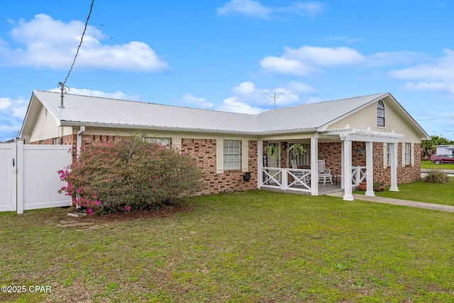 view of front of home featuring fence, a pergola, a front lawn, brick siding, and metal roof