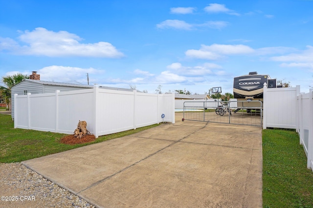 view of patio / terrace featuring a gate, concrete driveway, and fence