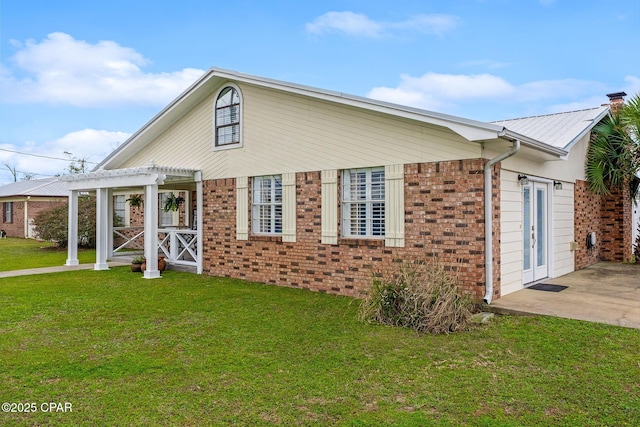 exterior space with brick siding, a patio, a pergola, and a yard