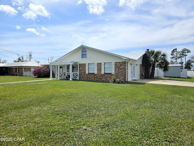 view of front of property featuring brick siding, concrete driveway, a pergola, and a front lawn