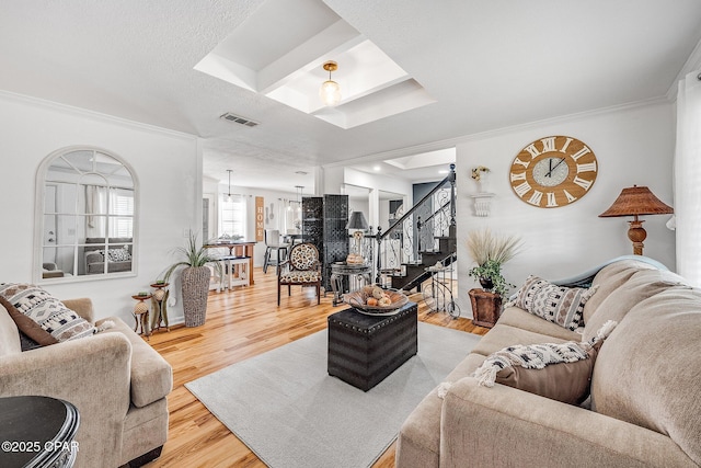 living room featuring visible vents, wood finished floors, stairs, and crown molding