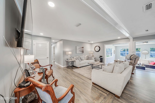 living area with a wealth of natural light, visible vents, and wood finished floors