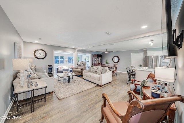 living room with visible vents, baseboards, light wood-style flooring, recessed lighting, and ceiling fan