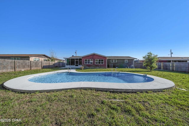 view of swimming pool with a yard, a fenced in pool, and a fenced backyard