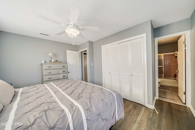 bedroom with a ceiling fan, visible vents, wood finished floors, a closet, and ensuite bathroom