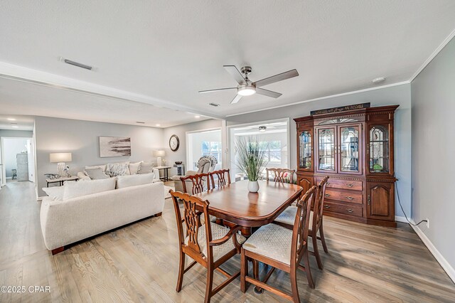 dining room featuring visible vents, ceiling fan, and light wood-style floors