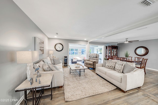 living room with a ceiling fan, wood finished floors, visible vents, and baseboards