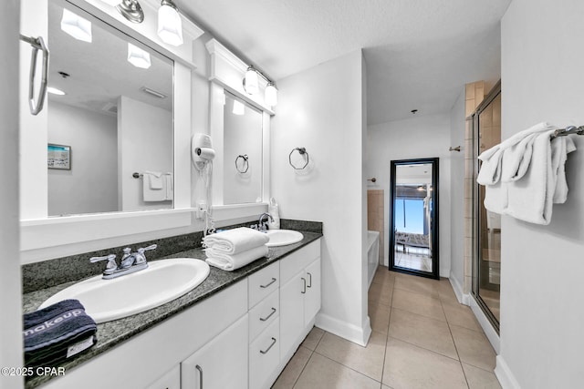 full bathroom featuring a sink, a shower stall, tile patterned floors, and double vanity