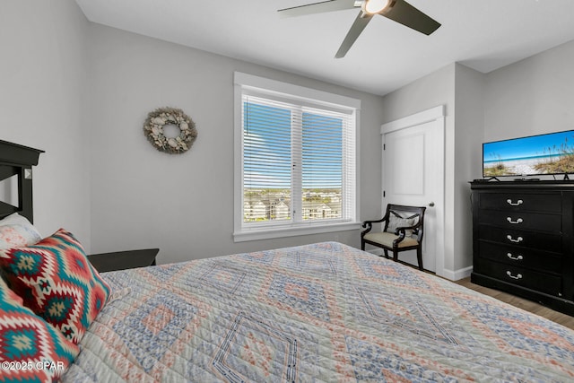 bedroom featuring baseboards, wood finished floors, and ceiling fan