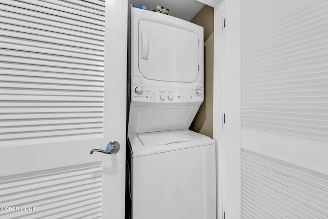 clothes washing area featuring laundry area and stacked washing maching and dryer