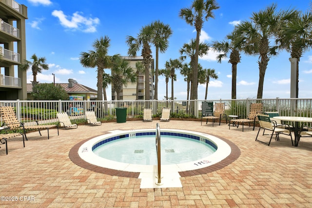 view of swimming pool with a community hot tub and fence