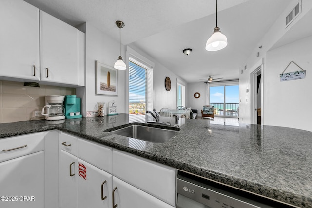 kitchen featuring visible vents, white cabinetry, a sink, dishwasher, and a wealth of natural light