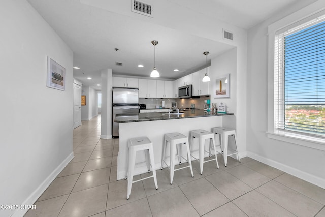 kitchen with light tile patterned floors, visible vents, tasteful backsplash, and appliances with stainless steel finishes