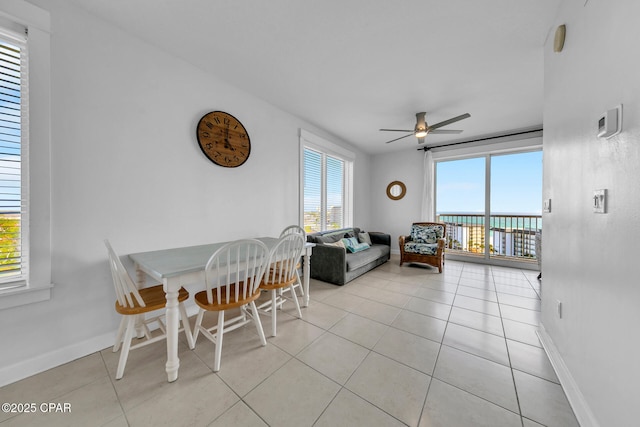 dining area with light tile patterned floors, baseboards, and ceiling fan