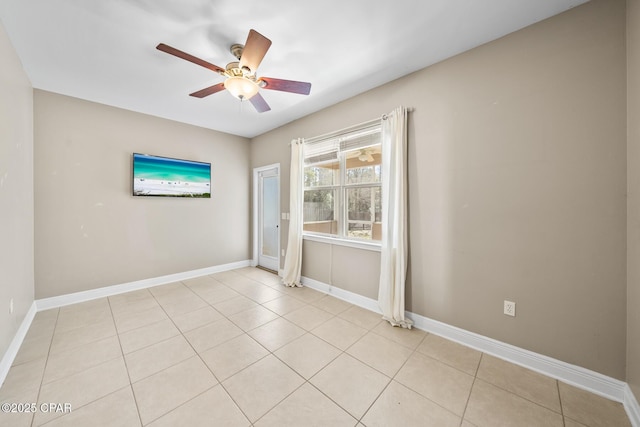 empty room featuring light tile patterned floors, baseboards, and ceiling fan