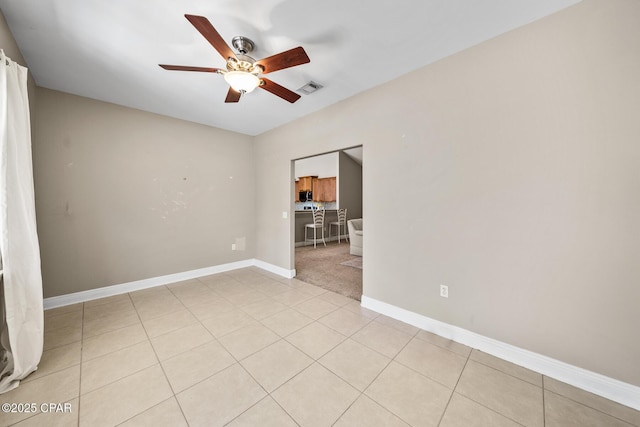 spare room featuring light tile patterned floors, visible vents, baseboards, and ceiling fan