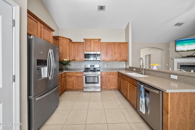 kitchen with visible vents, backsplash, light tile patterned floors, stainless steel appliances, and a sink