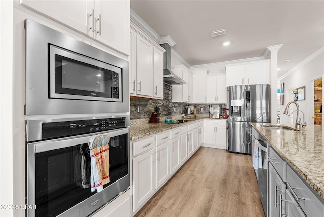 kitchen featuring a sink, stainless steel appliances, white cabinetry, crown molding, and tasteful backsplash