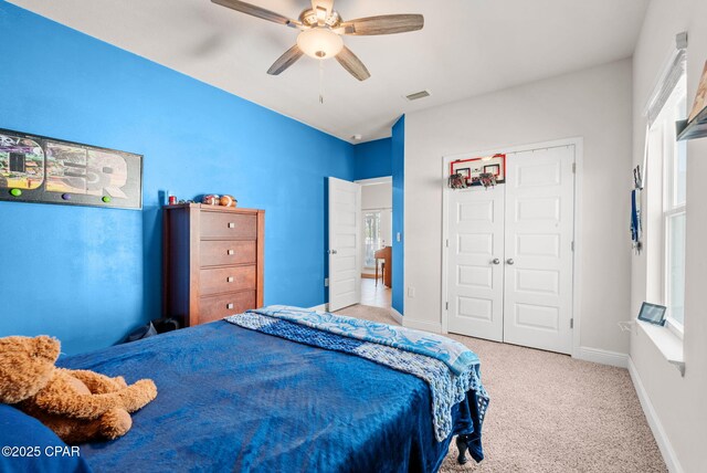 carpeted bedroom with a ceiling fan, baseboards, visible vents, and a closet