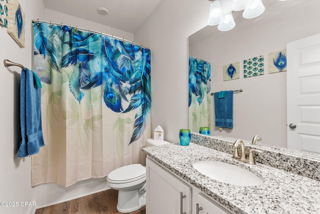 full bath featuring toilet, wood finished floors, and vanity