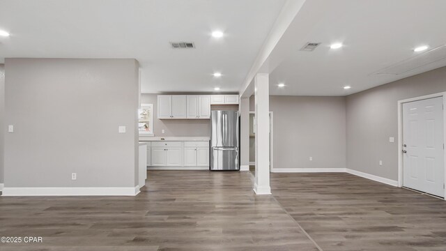 unfurnished living room featuring recessed lighting, wood finished floors, visible vents, and baseboards