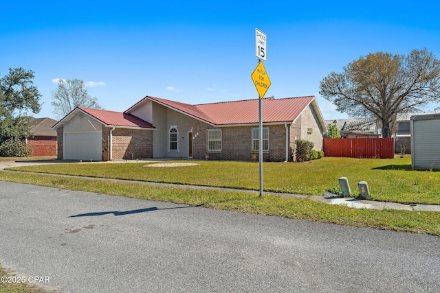 view of front facade featuring brick siding, fence, a front yard, metal roof, and an attached garage