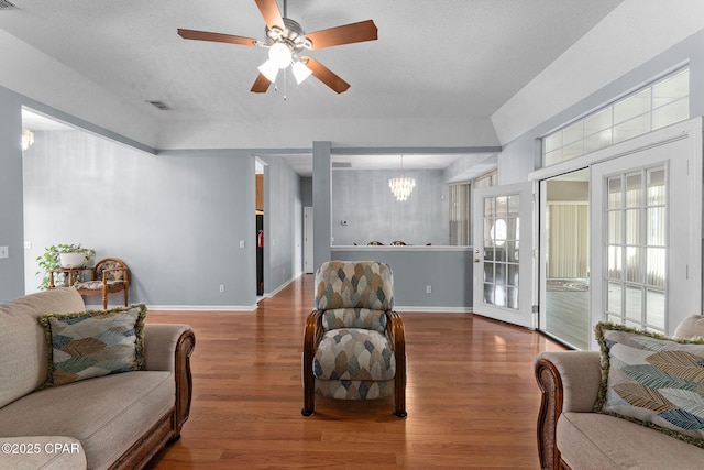 living area with wood finished floors, visible vents, and baseboards