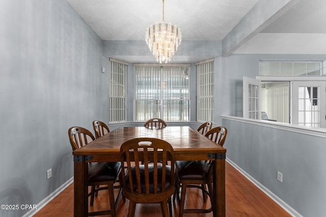 dining room featuring wood finished floors, baseboards, and a chandelier