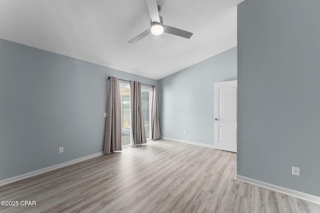 unfurnished room featuring wood finished floors, baseboards, lofted ceiling, ceiling fan, and a textured ceiling