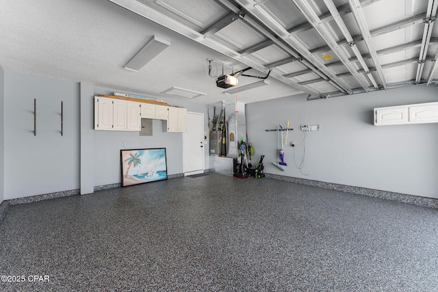 garage with electric panel, baseboards, a garage door opener, and water heater