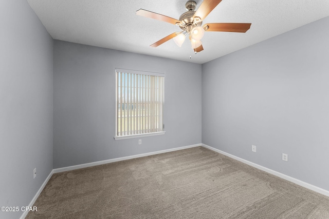 carpeted spare room featuring a textured ceiling, baseboards, and ceiling fan