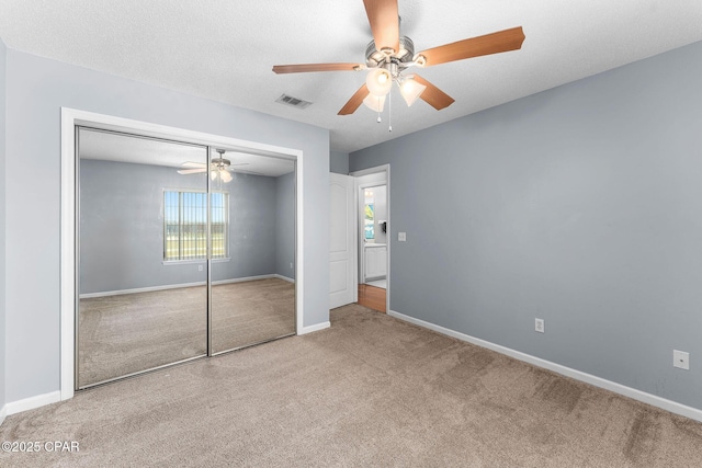 unfurnished bedroom featuring carpet flooring, baseboards, visible vents, and a closet