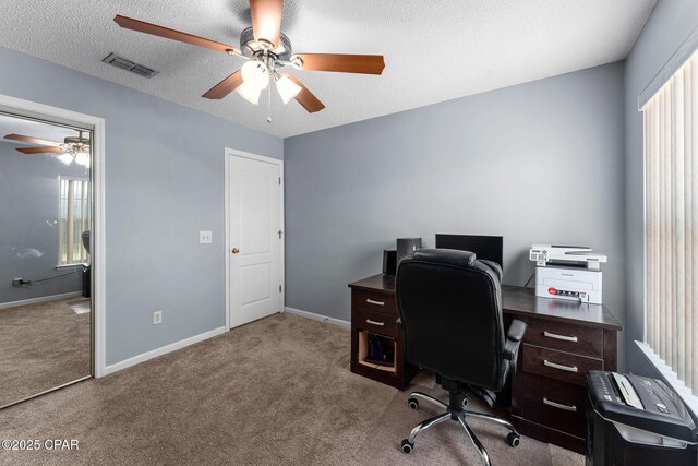 home office with visible vents, carpet flooring, a textured ceiling, and ceiling fan