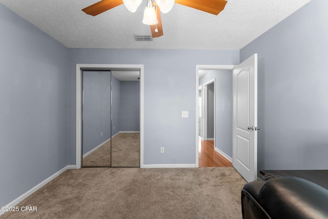 bedroom with a closet, visible vents, baseboards, and carpet