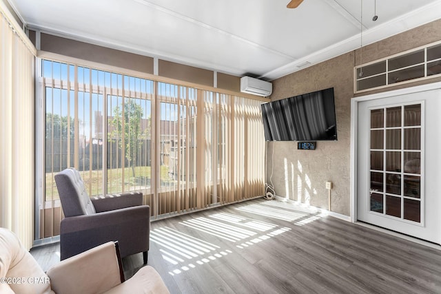 unfurnished sunroom featuring ceiling fan and a wall unit AC