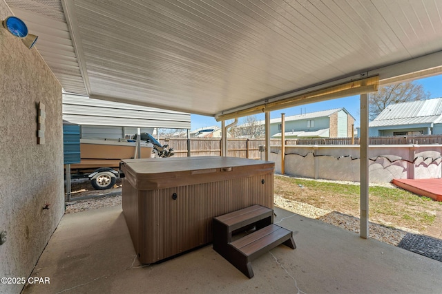 view of patio featuring a hot tub and fence