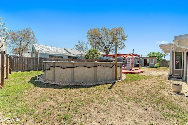 view of yard featuring a fenced in pool, a wooden deck, a fenced backyard, and a pergola