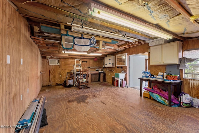 basement featuring wooden walls and a wall unit AC