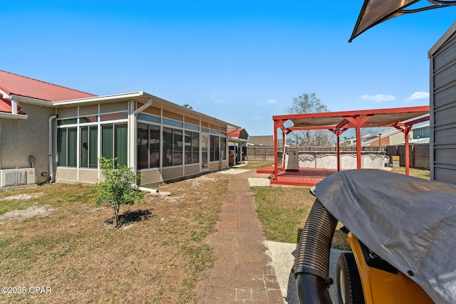 view of yard with ac unit, a fenced backyard, and a sunroom