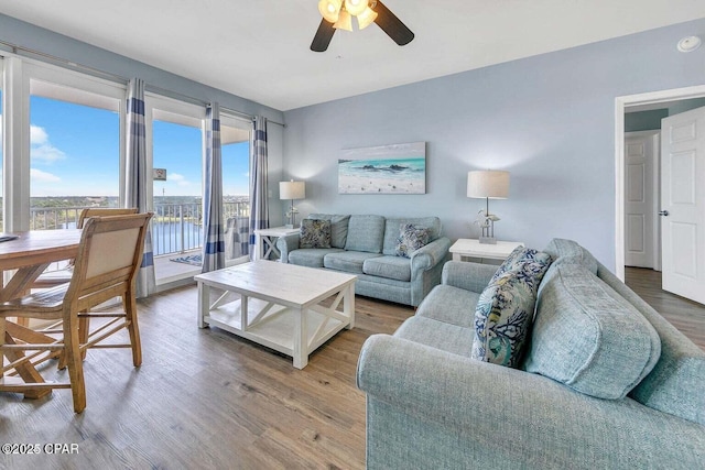 living room featuring light wood-type flooring and a ceiling fan